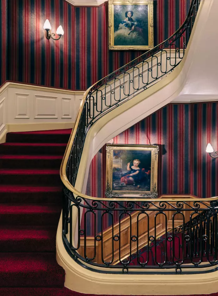 Deep-red and cream accented staircase inside 47 Park Street in London, England