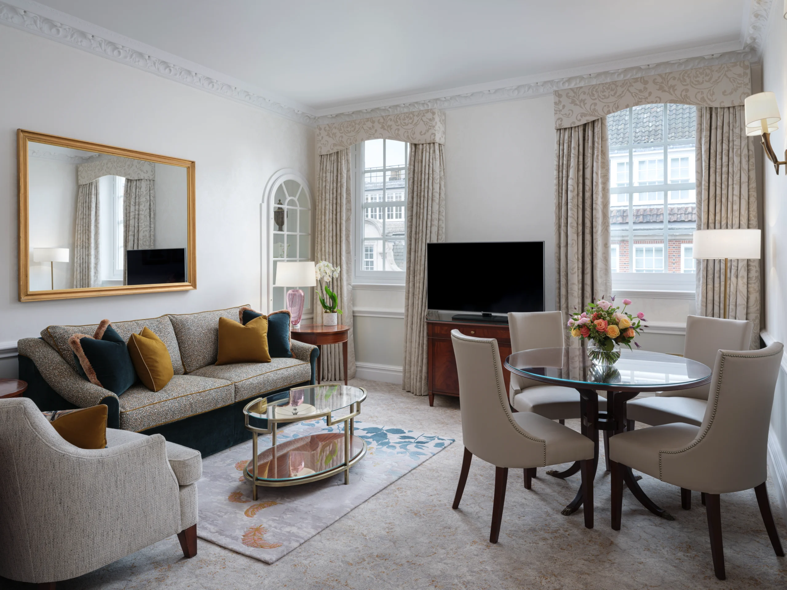 View of an elegant room with sofa and coffee table, armchair, and round dining table and chairs