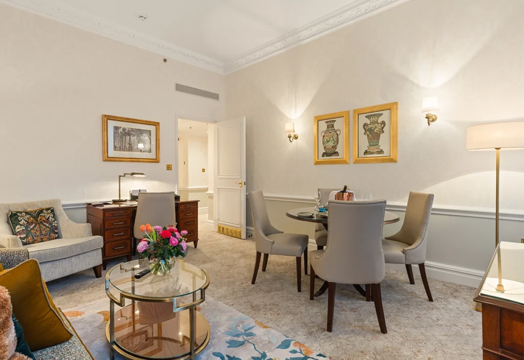 View of an elegant room with sofa and coffee table, armchair, and round dining table and chairs